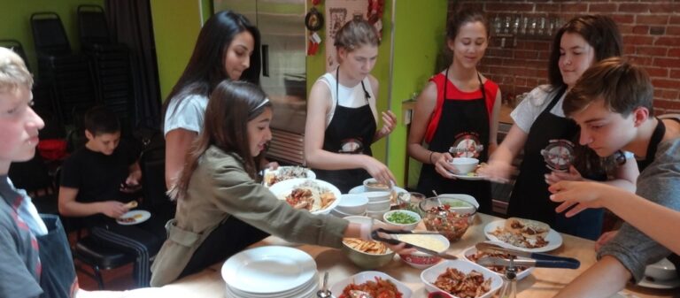 a group of people sitting at a table with a plate of food
