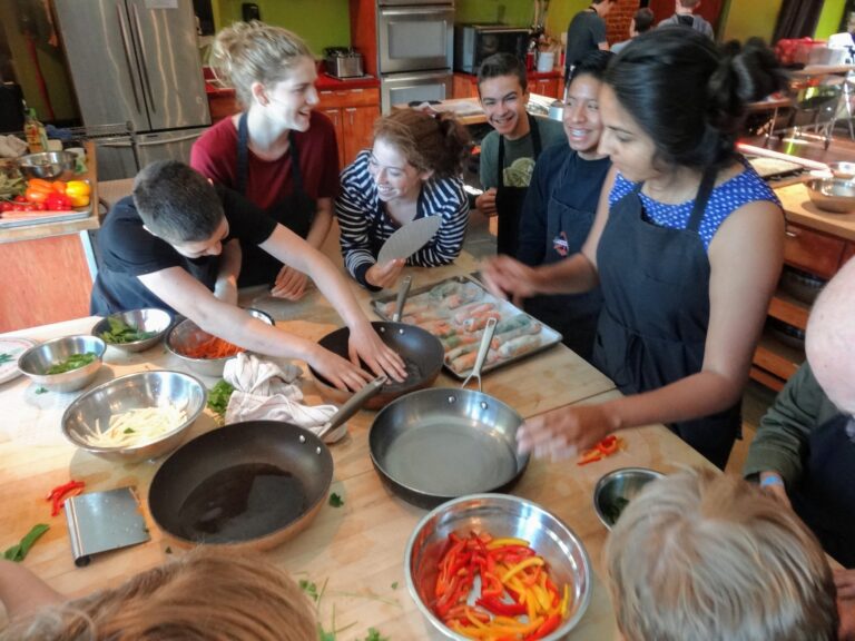 a group of people sitting at a table with food