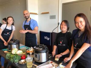 a group of people standing in a kitchen preparing food